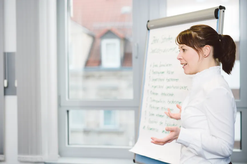 Eine Person hält einen Vortrag vor einem Flipchart