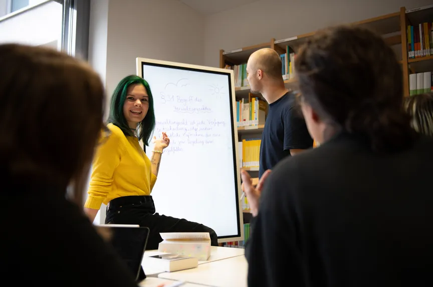 Eine Gruppe Studierender macht eine Gruppenarbeit in einer Bibliothek